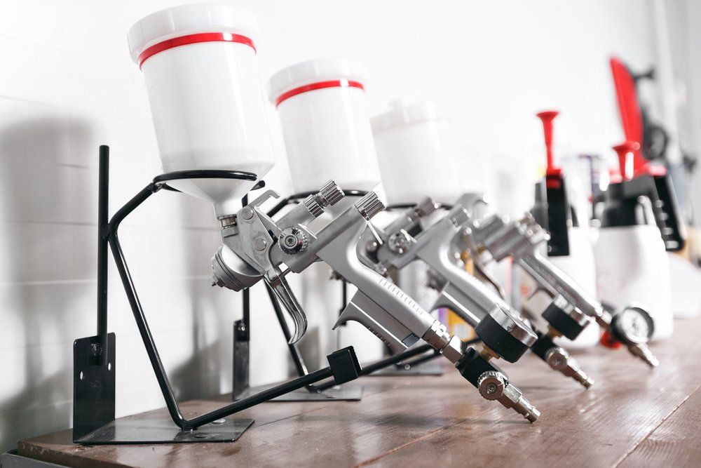An Image of Color White Spray Guns in a Straight Line With White Background — Dynamic 2-Pack In Rockville, QLD