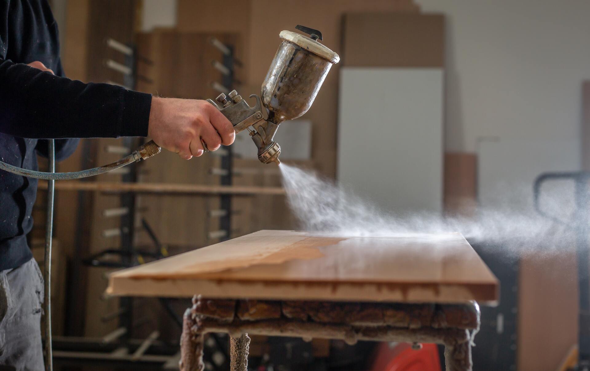 A Person is Spraying Paint on a Wooden Table — Dynamic 2-Pack In Rockville, QLD