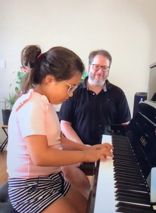 Un homme et une fille jouent du piano ensemble