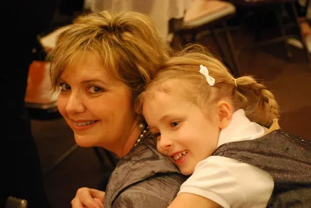A woman is holding a little girl in her arms.