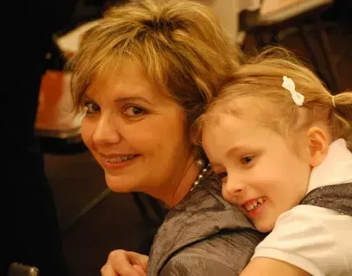 A woman is holding a little girl in her arms.