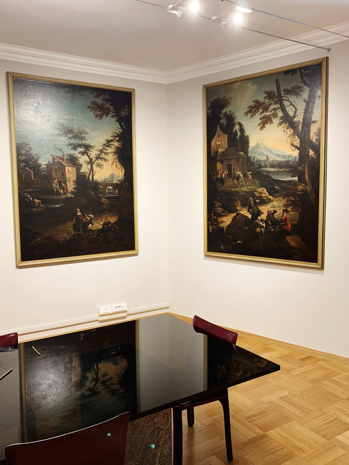 Una stanza con due quadri sul muro e un tavolo