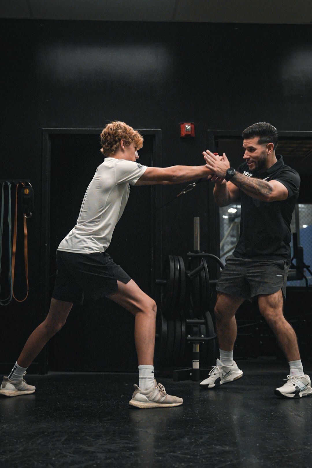 Two men are standing next to each other in a gym.
