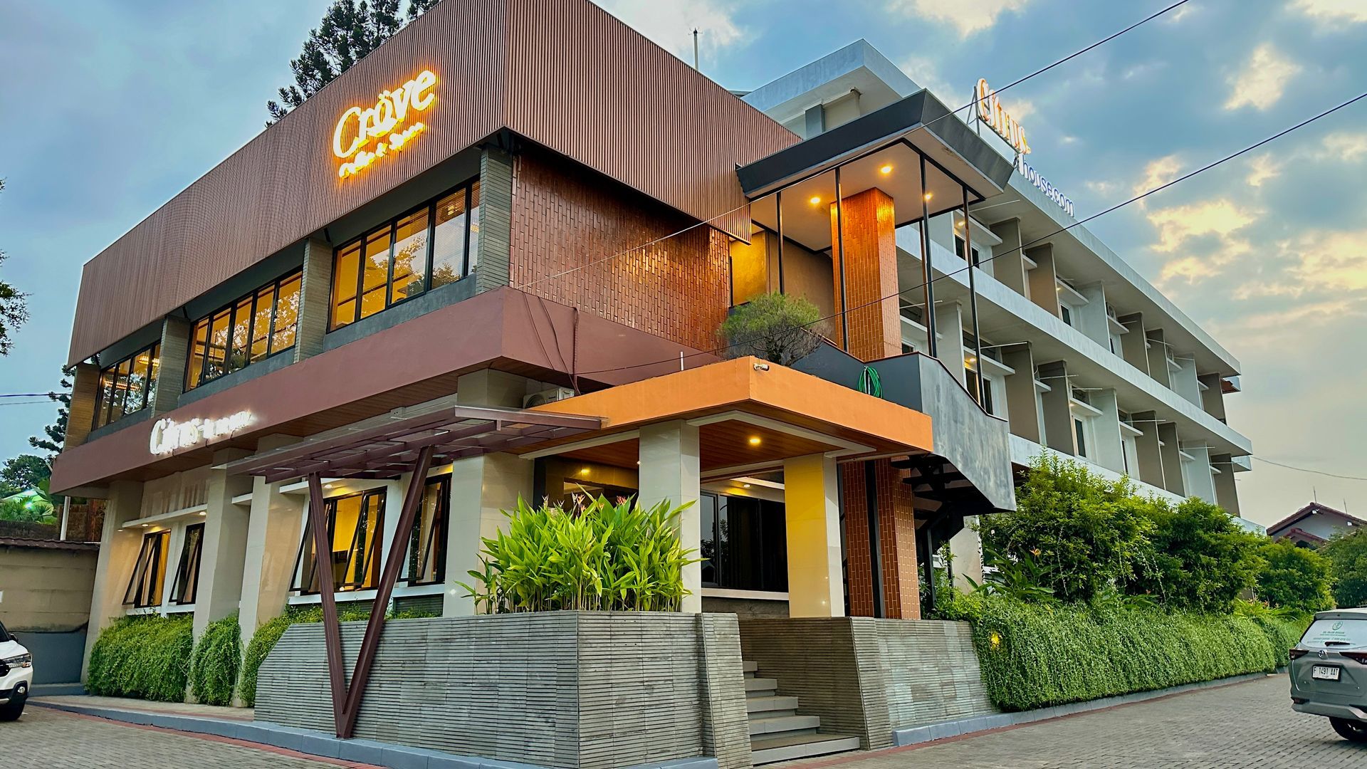 Hotel exterior with brown, orange, and white facade. Signage reads 