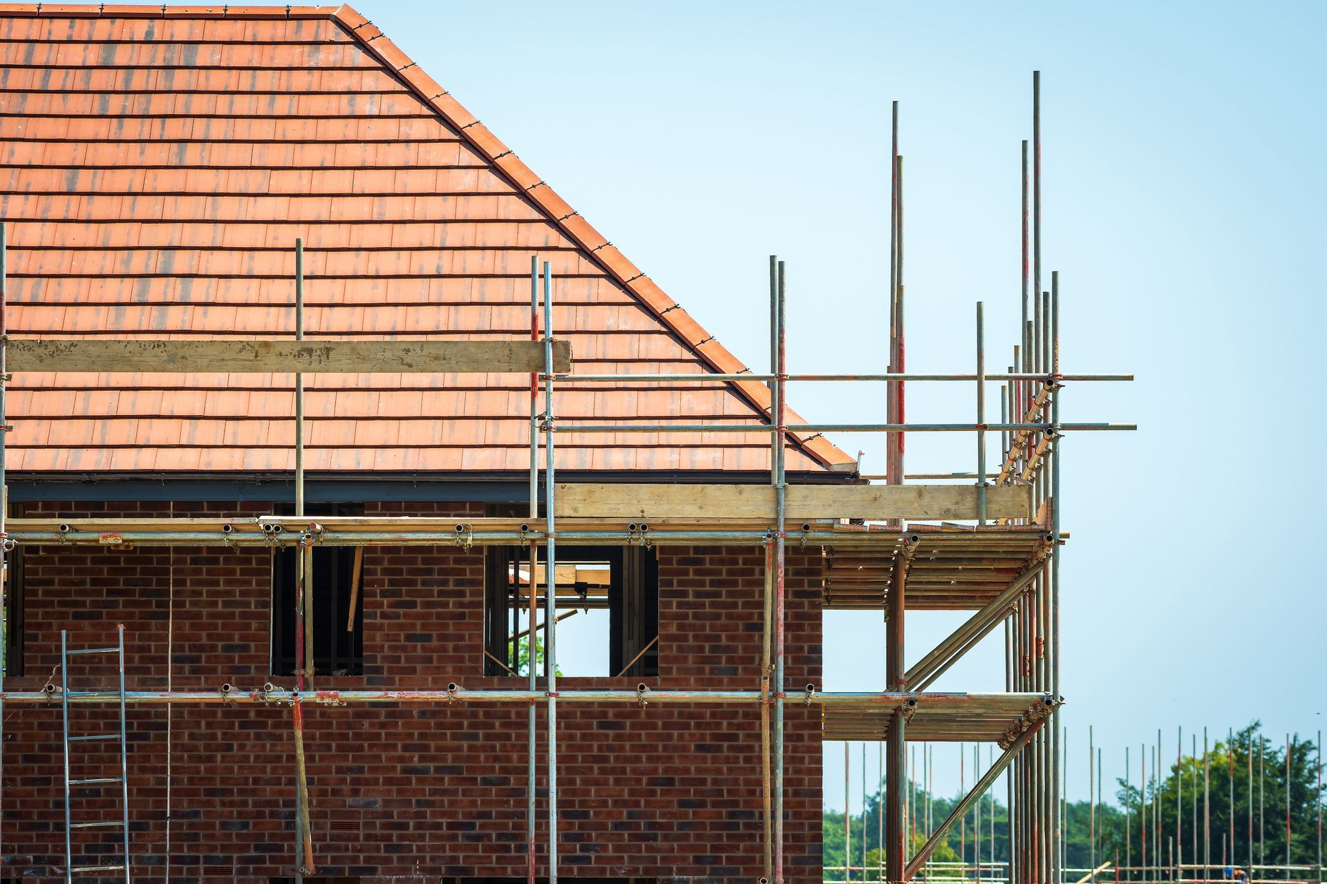 A brick house is being built with scaffolding around it.