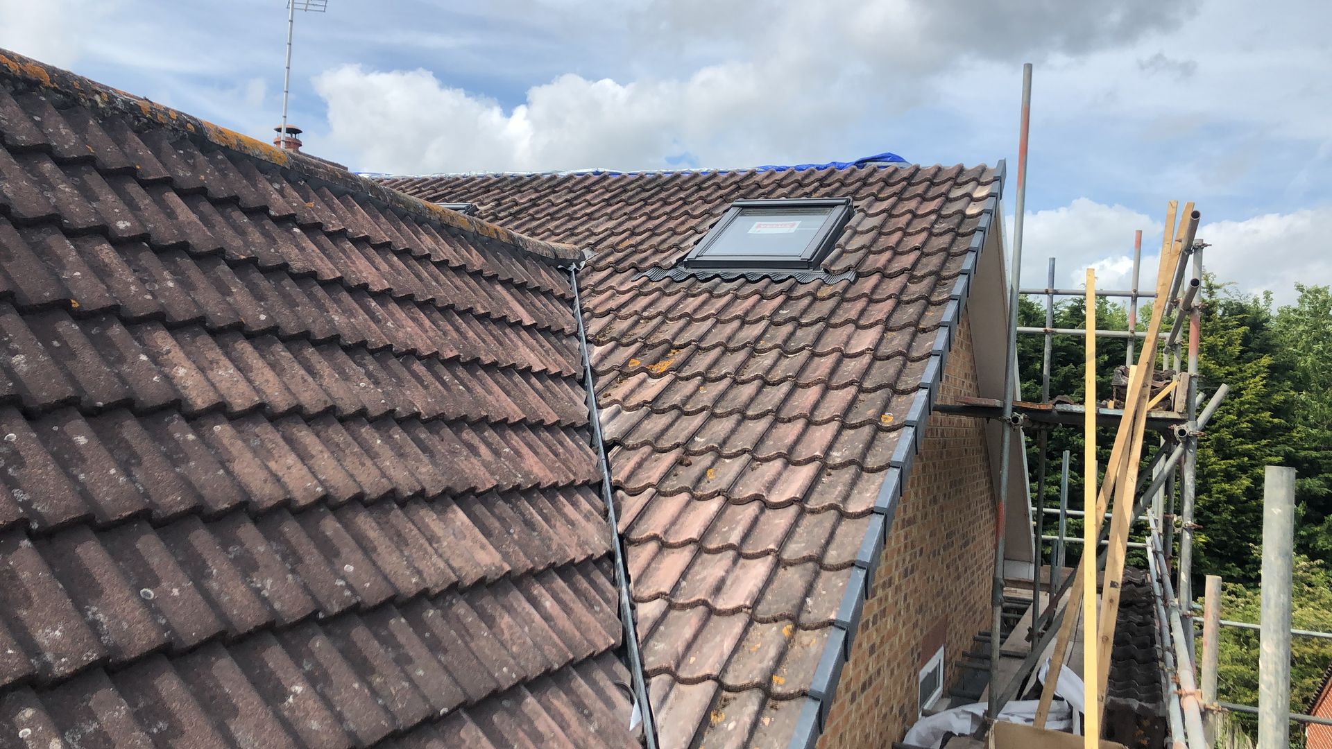 A roof with a skylight on it is being remodeled.