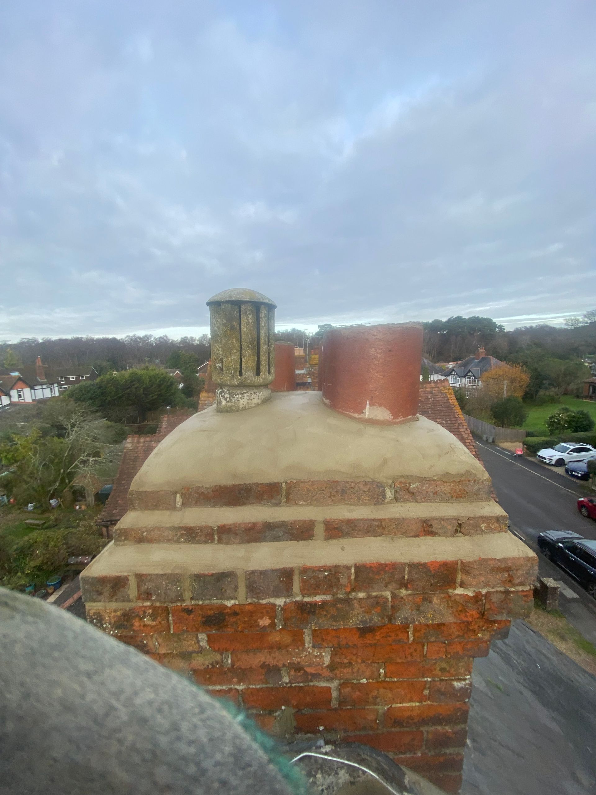 A brick chimney on top of a building with a blue sky in the background.