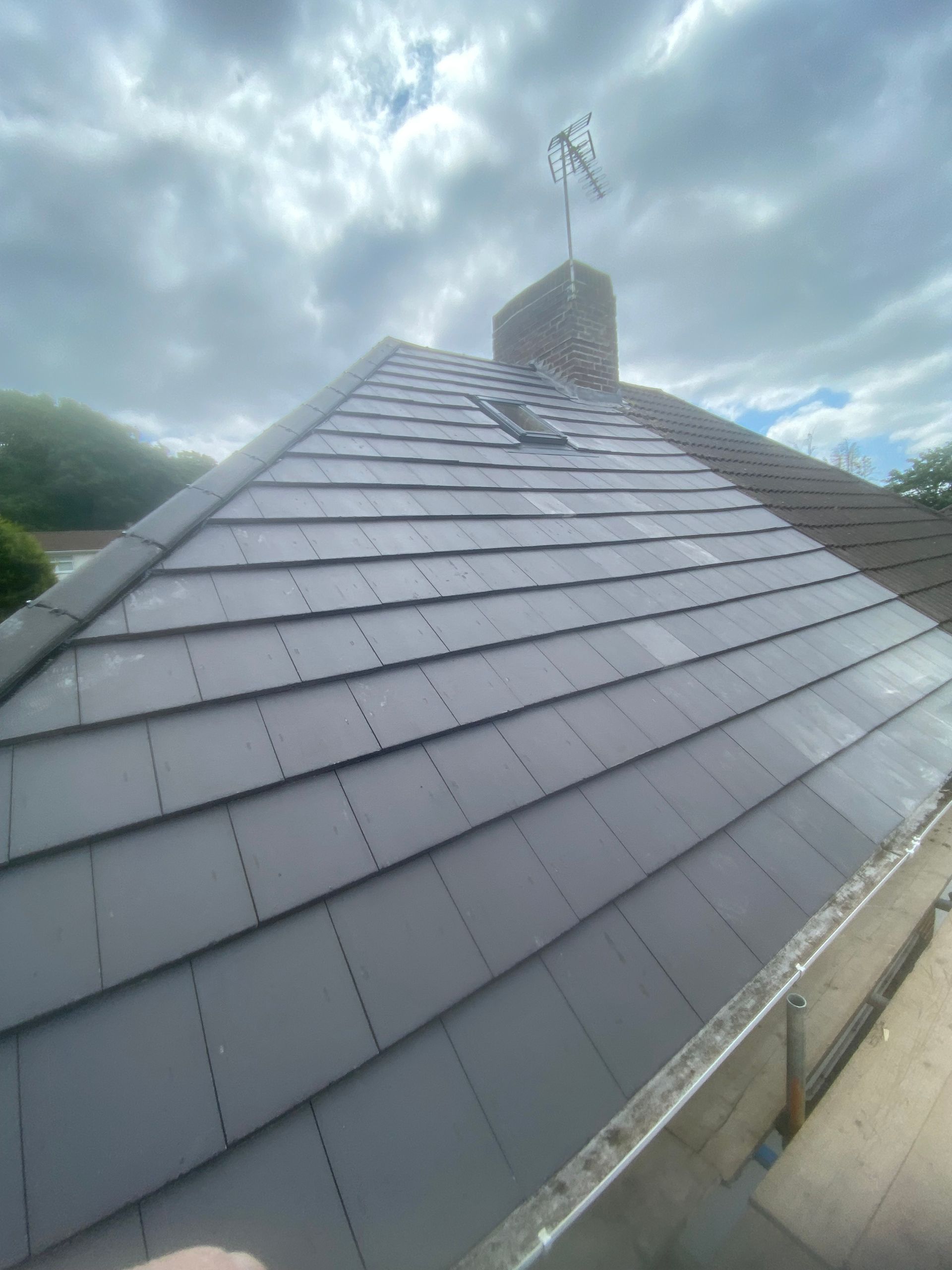 A close up of a roof with a chimney on top of it.