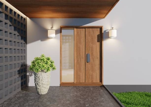 Entrance to a house with a large wooden door, with gray walls, showcasing door replacement service.