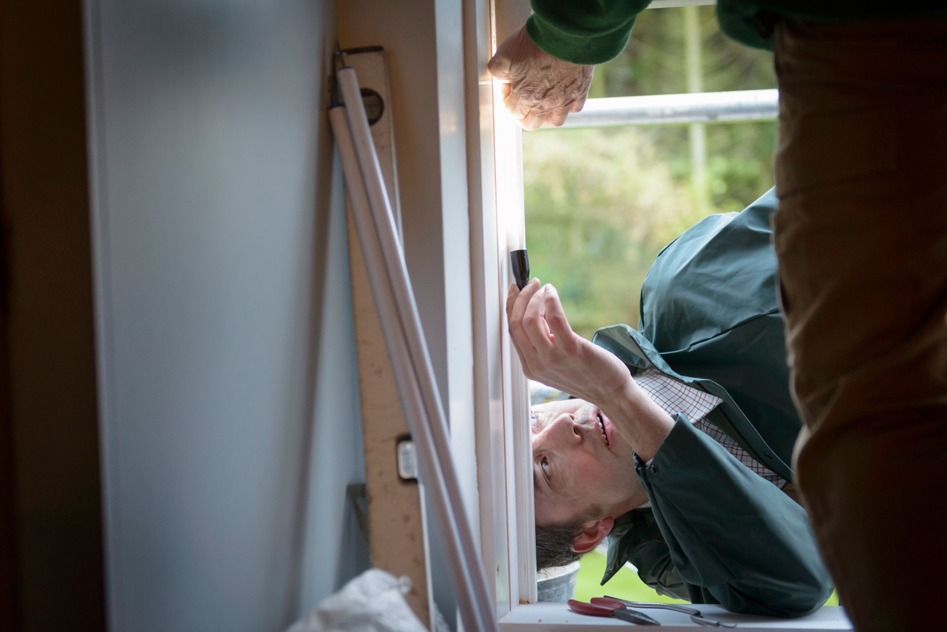 Two contractors adjusting new window in house, showcasing excellent window installation. Two contractors adjusting new window in house, showcasing excellent window installation.