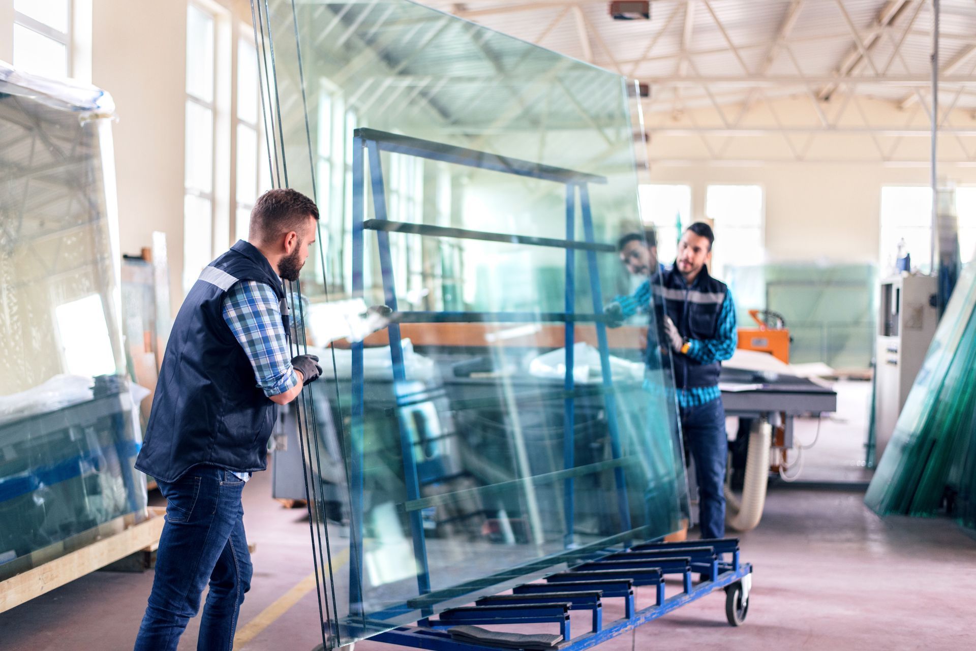 Picture of workers packaging glass sheets in a warehouse.