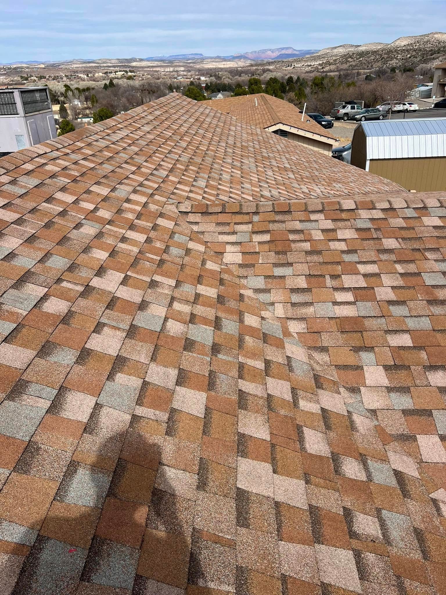 Overhead view of a multi-colored asphalt shingle roof on a sunny day.