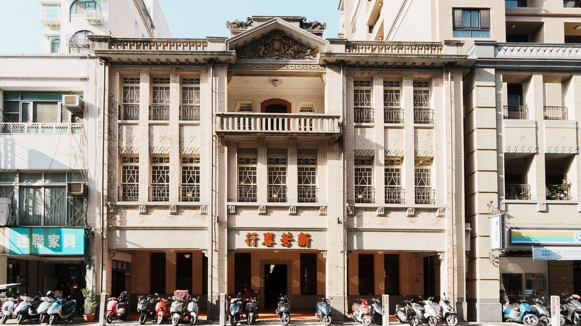 一間光線昏暗的房間，裡面有投影螢幕、桌椅和餐桌椅。