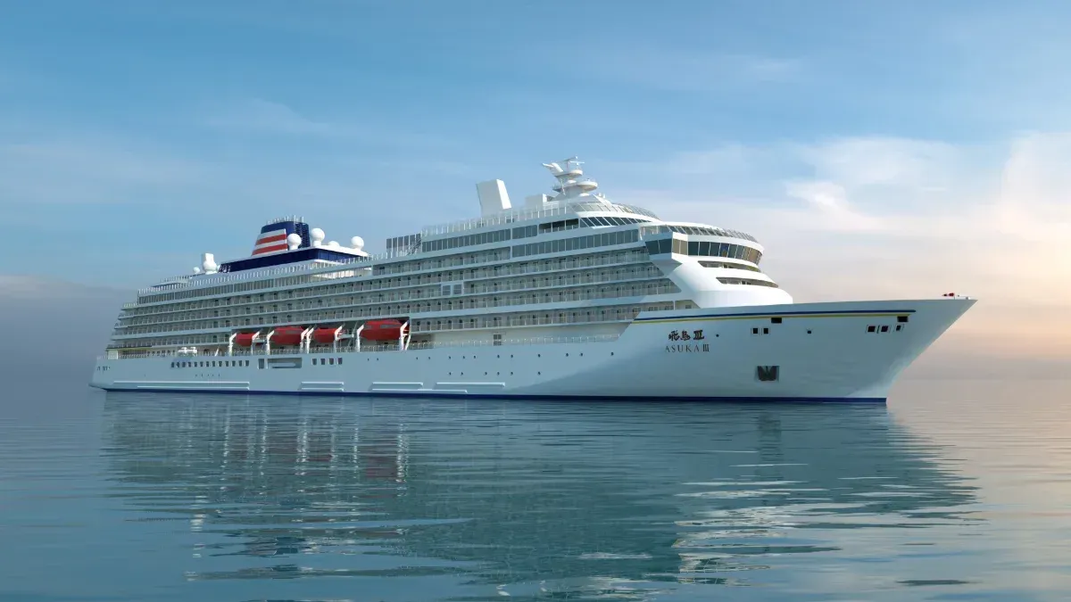 Cruise ship on calm blue water under a clear sky.