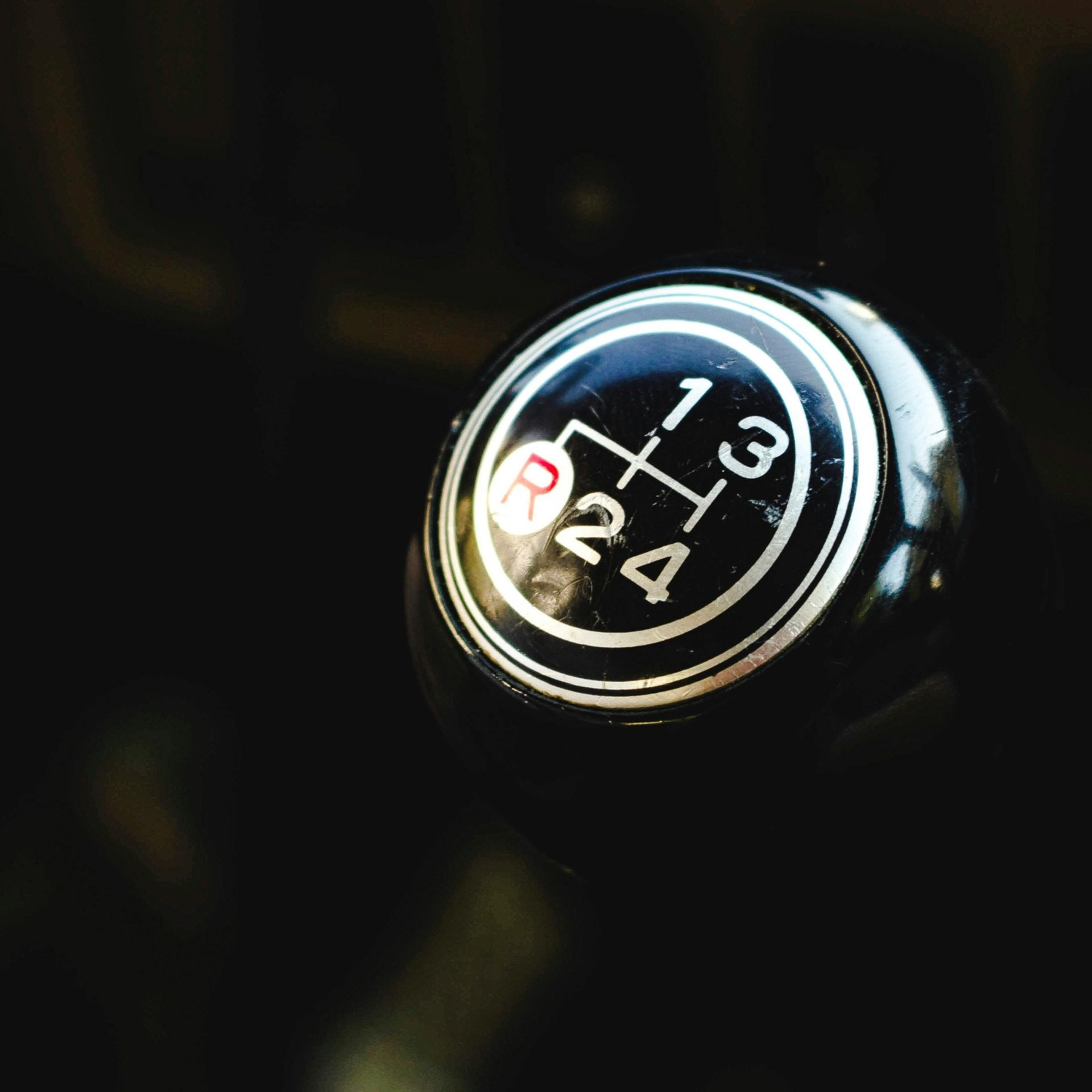 Black gear shift knob with white numbers and markings, showing the gear positions.