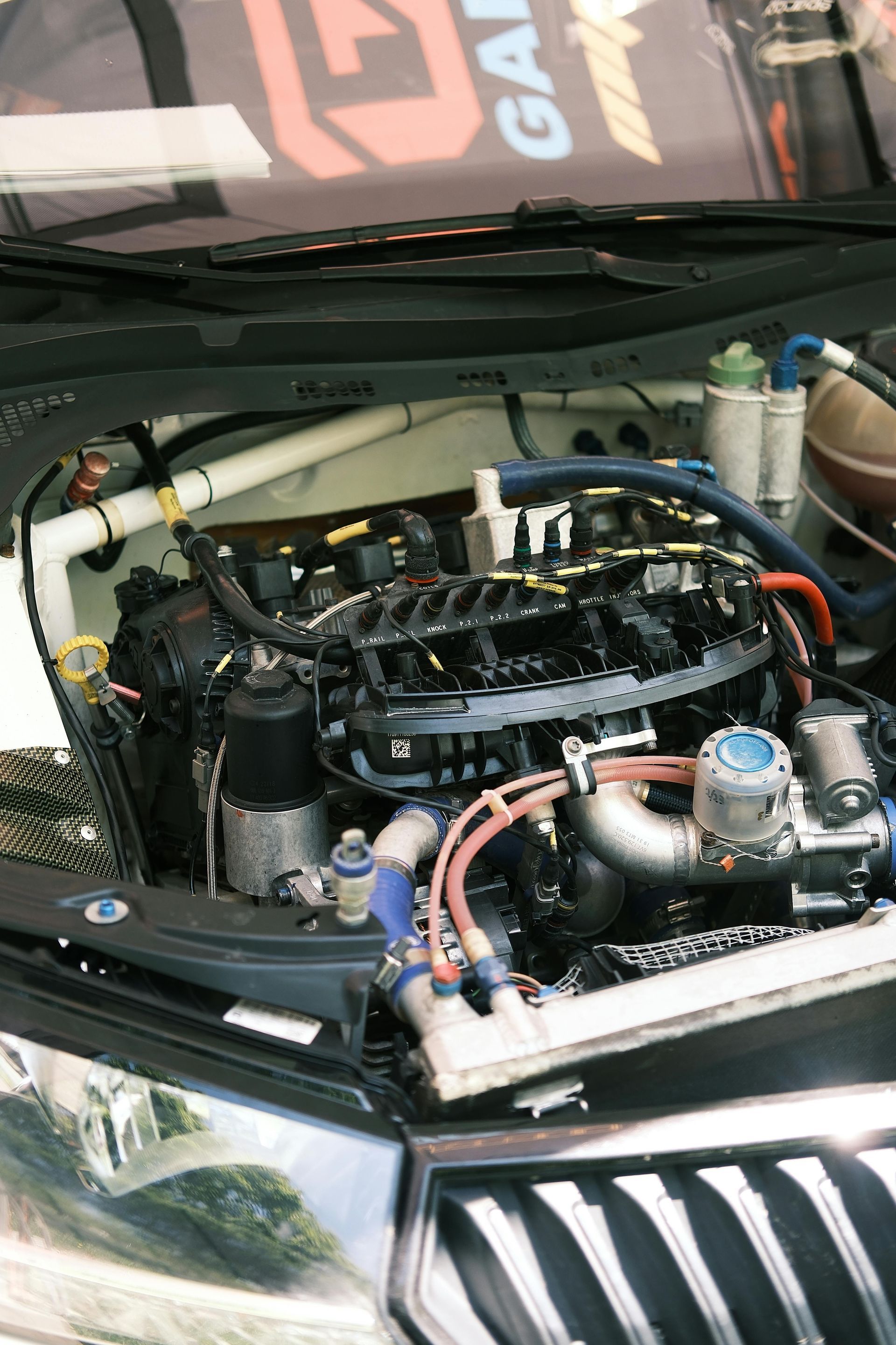 Engine bay of a rally car, showcasing the engine and various components. 