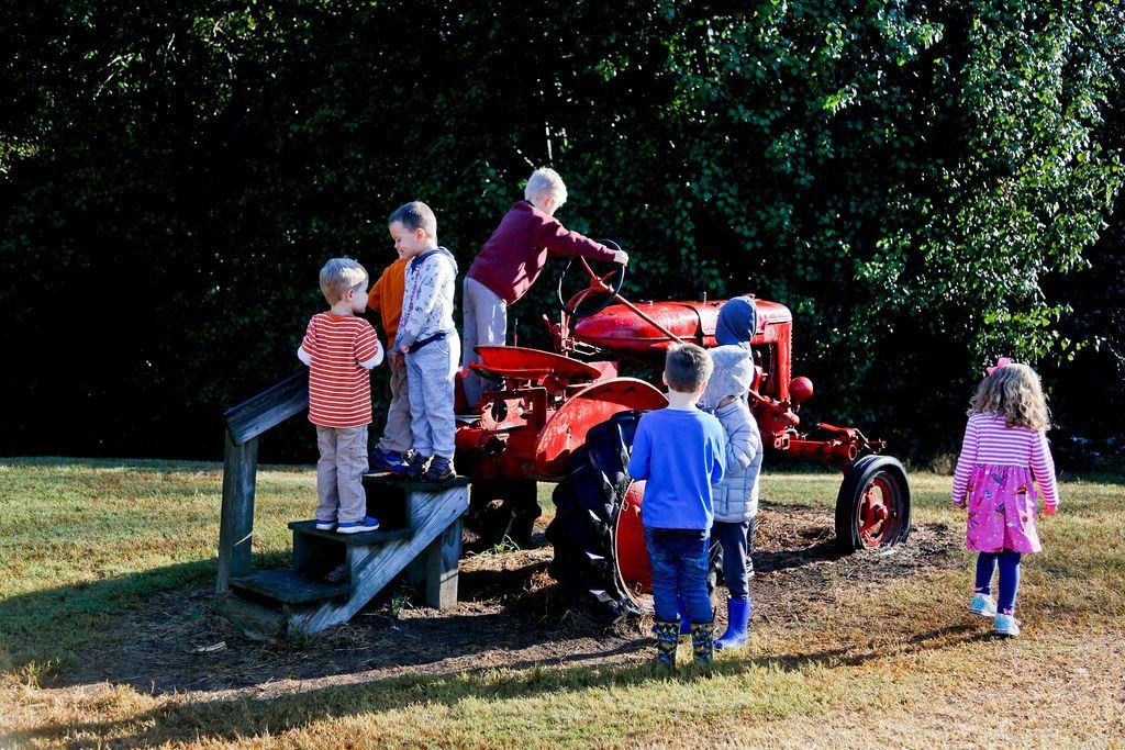 Montessori children playing on a tractor