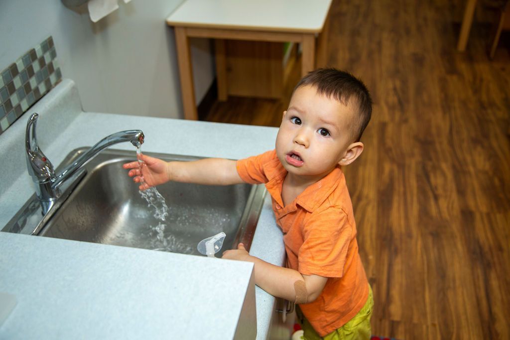 Montessori child washing his hands