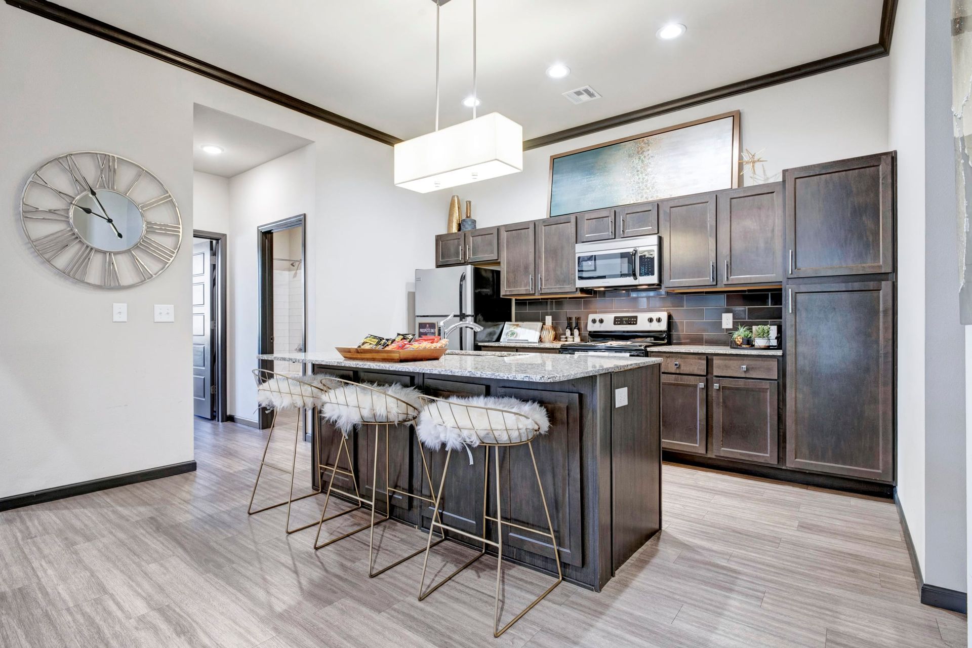 A kitchen with a large island and a clock on the wall.