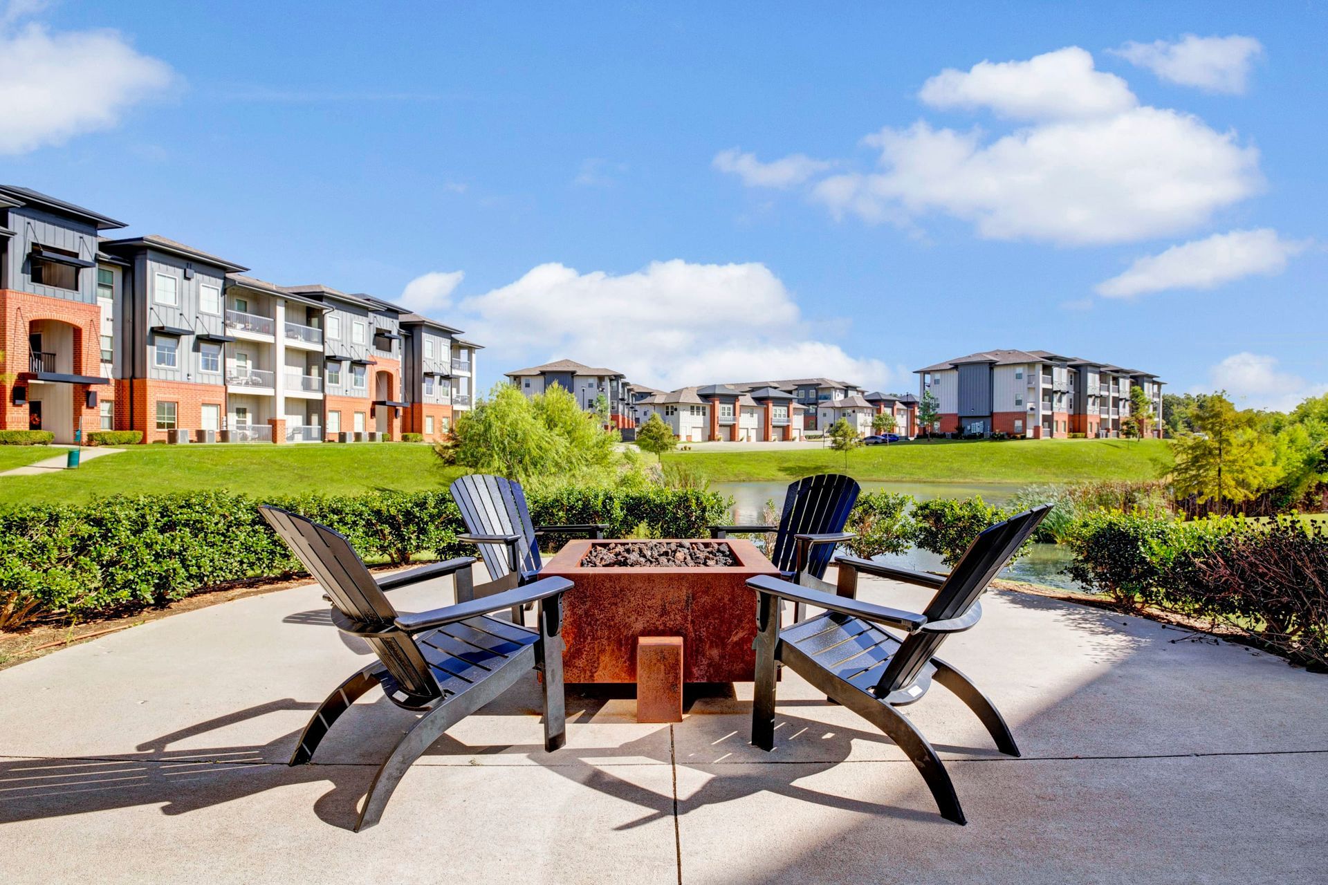 Two chairs are sitting around a fire pit in front of a building.