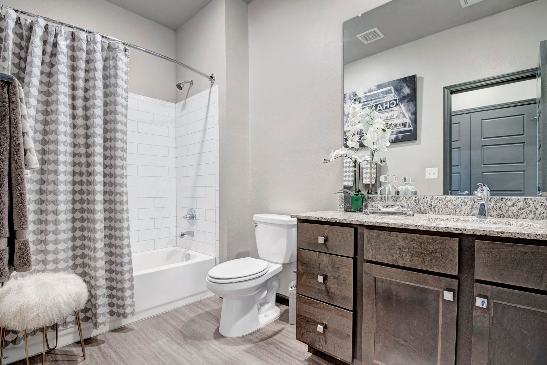 A bathroom with a toilet , sink , shower and mirror.