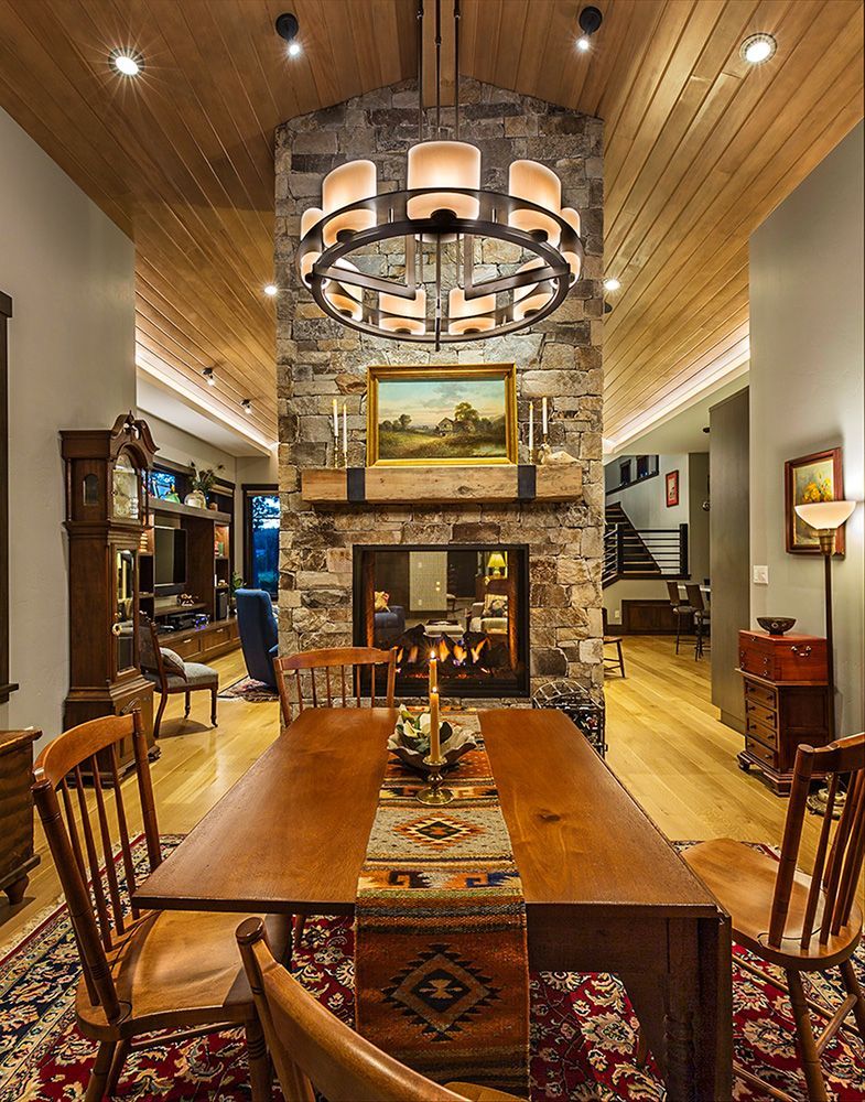 A dining room with a table and chairs and a fireplace