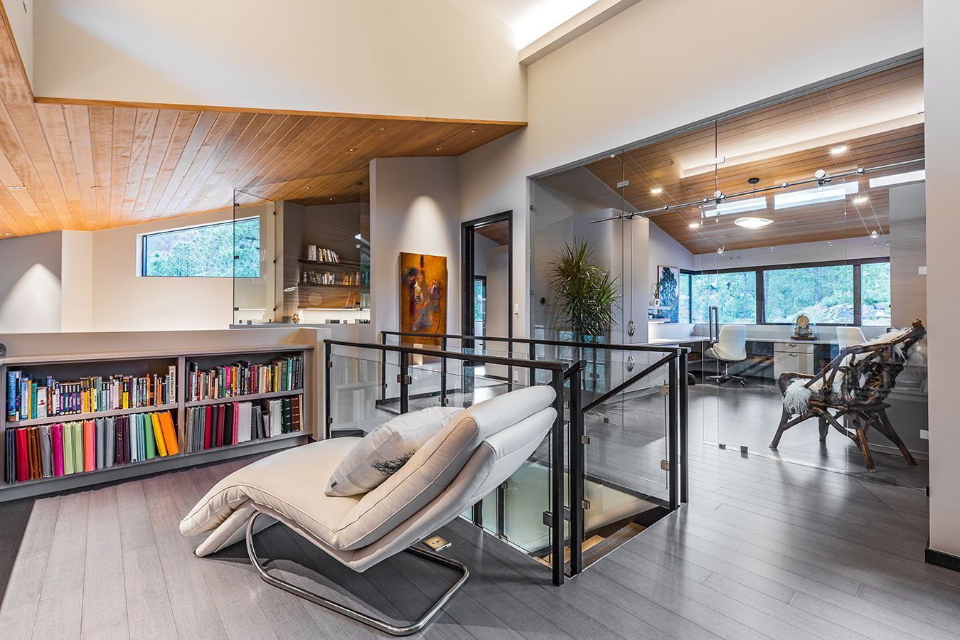 A living room with a chaise lounge and a bookshelf.