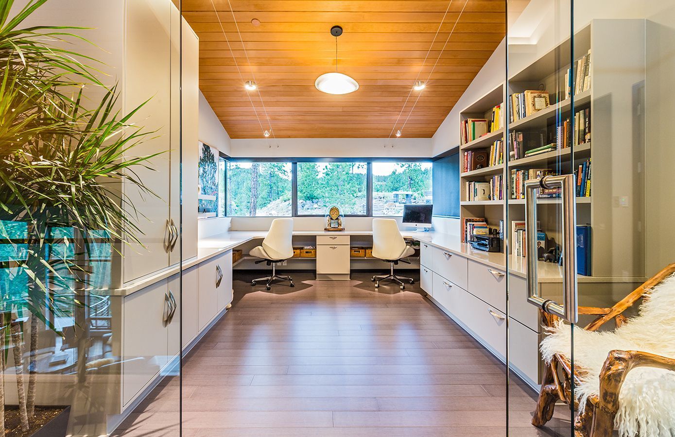 A long room with a glass door leading to a home office.