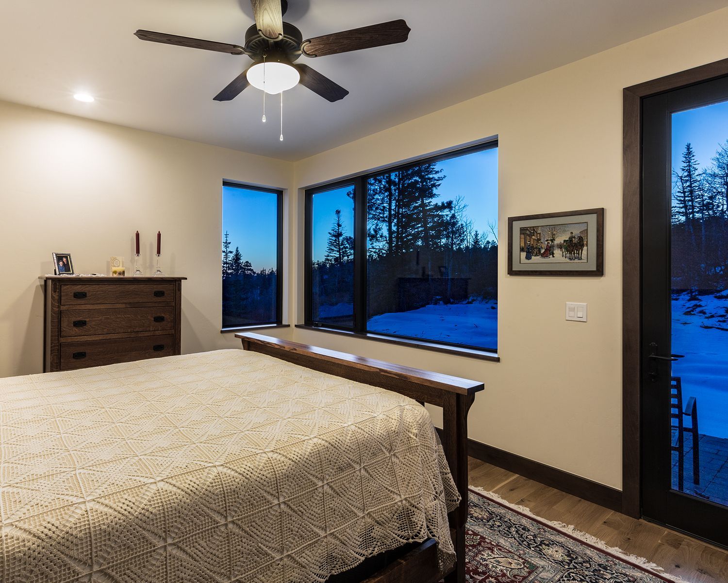 A bedroom with a bed , dresser , and ceiling fan.