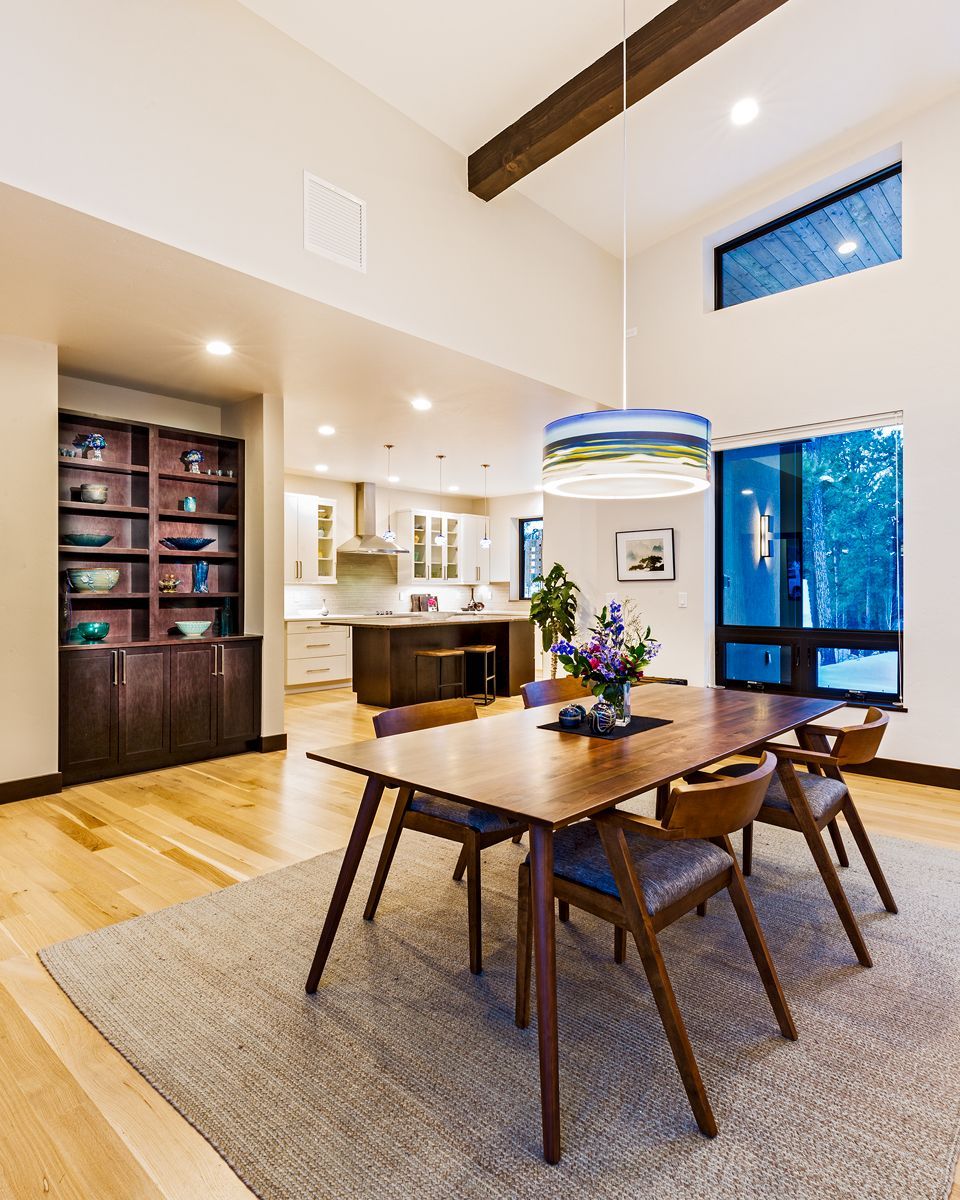 A dining room with a table and chairs and a rug.