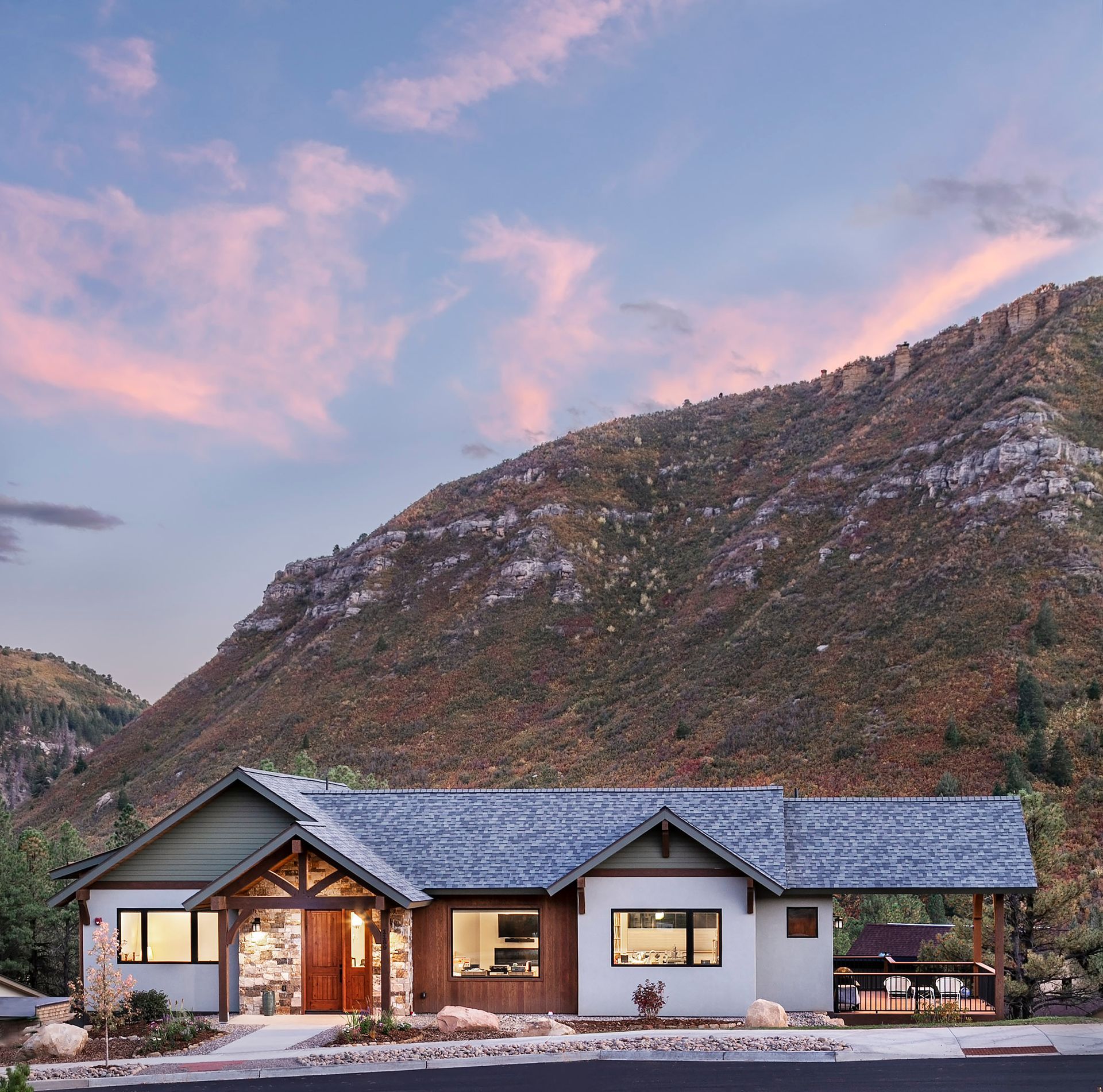 A house with a blue roof and a mountain in the background