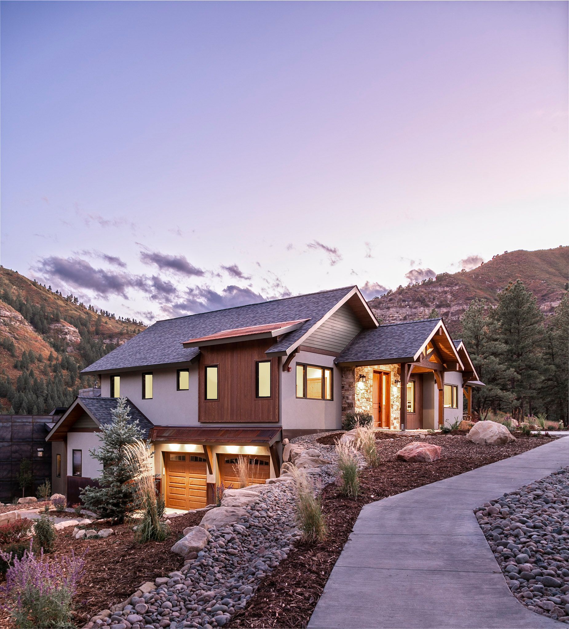 A large house is sitting on top of a hill in the mountains.