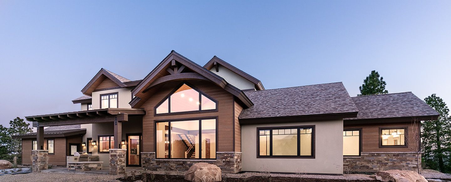 A large house with a lot of windows is sitting on top of a hill.