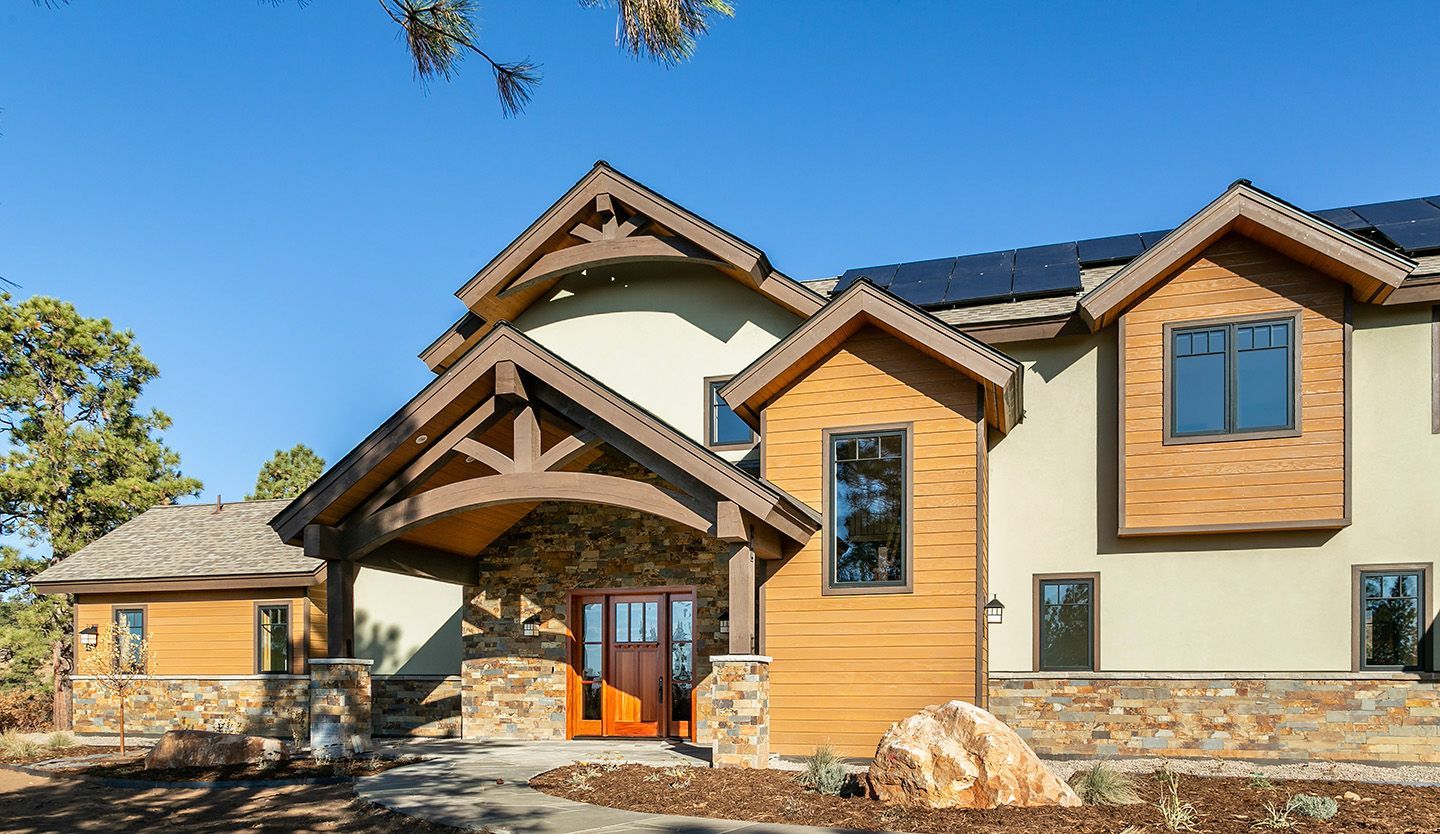 A large house with a lot of windows and solar panels on the roof.