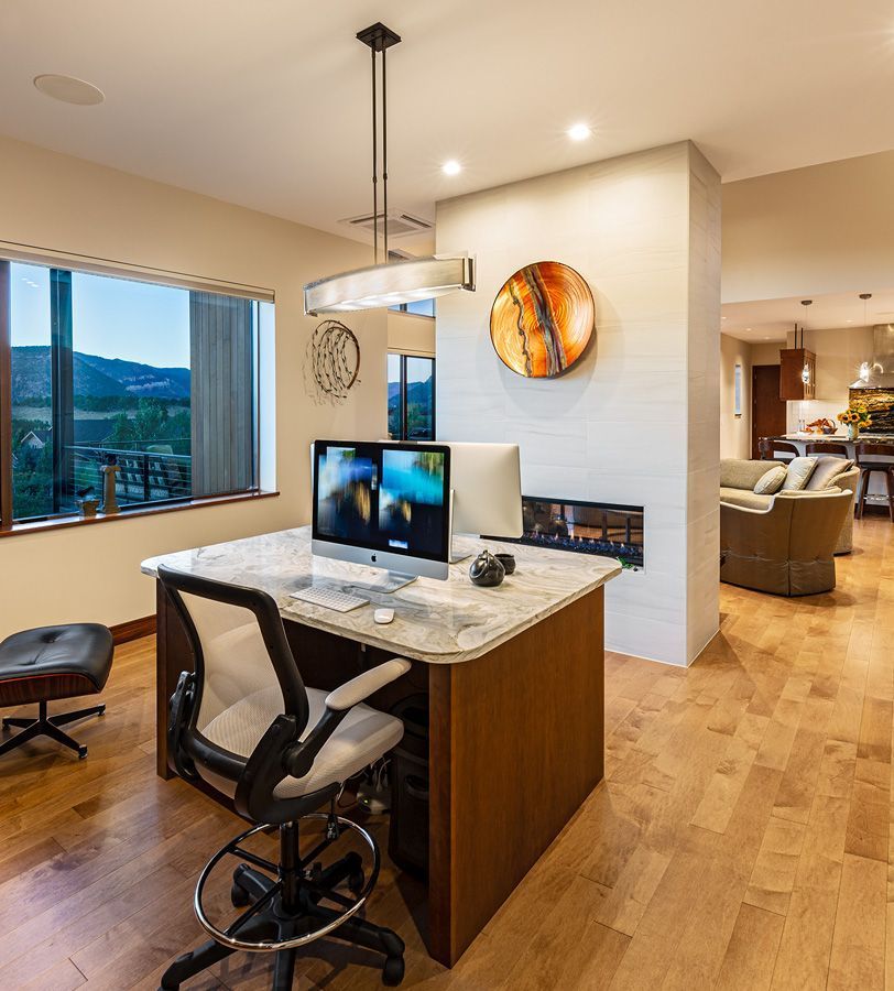 A desk with a computer on it in a living room
