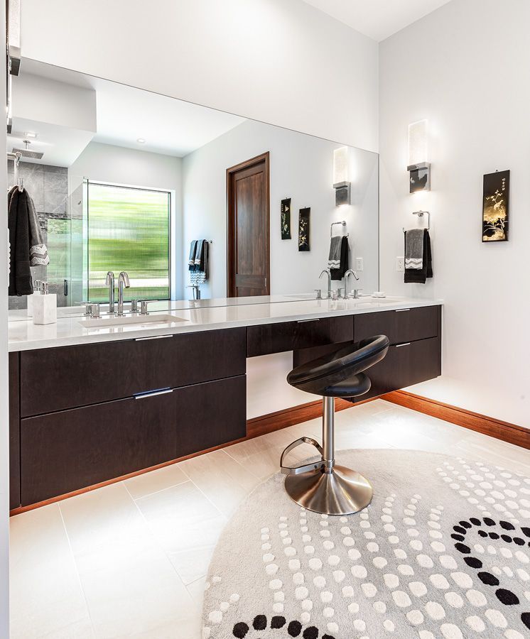 A bathroom with two sinks and a large mirror