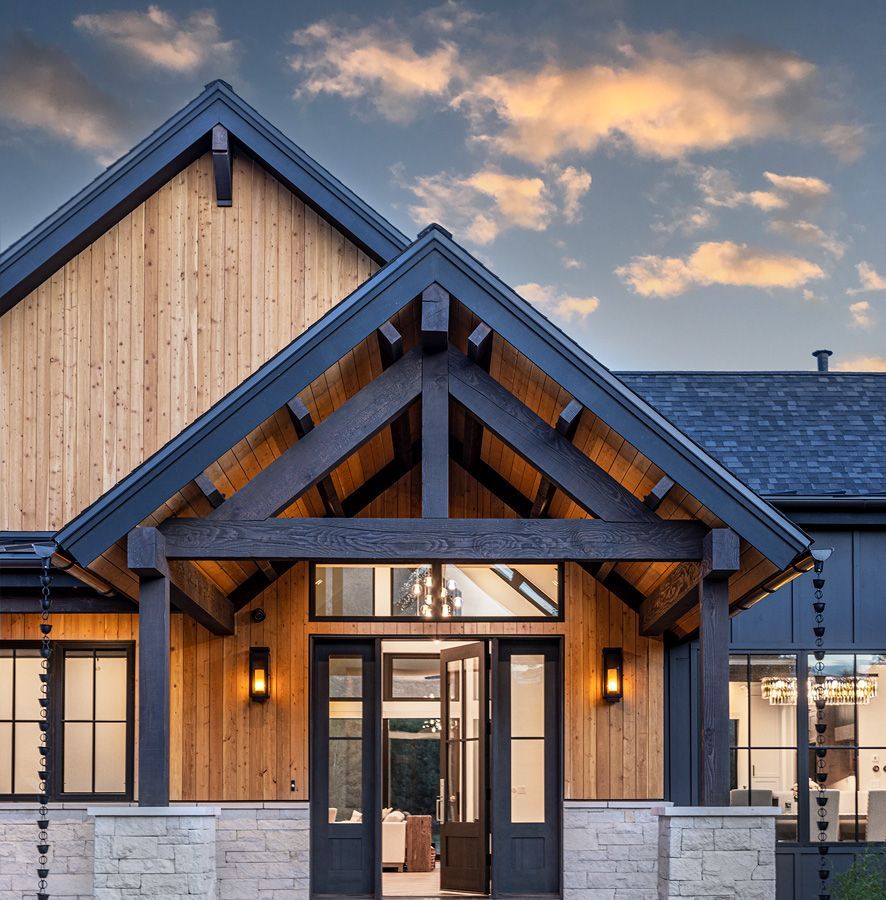 The front of a house with a wooden roof and a black roof