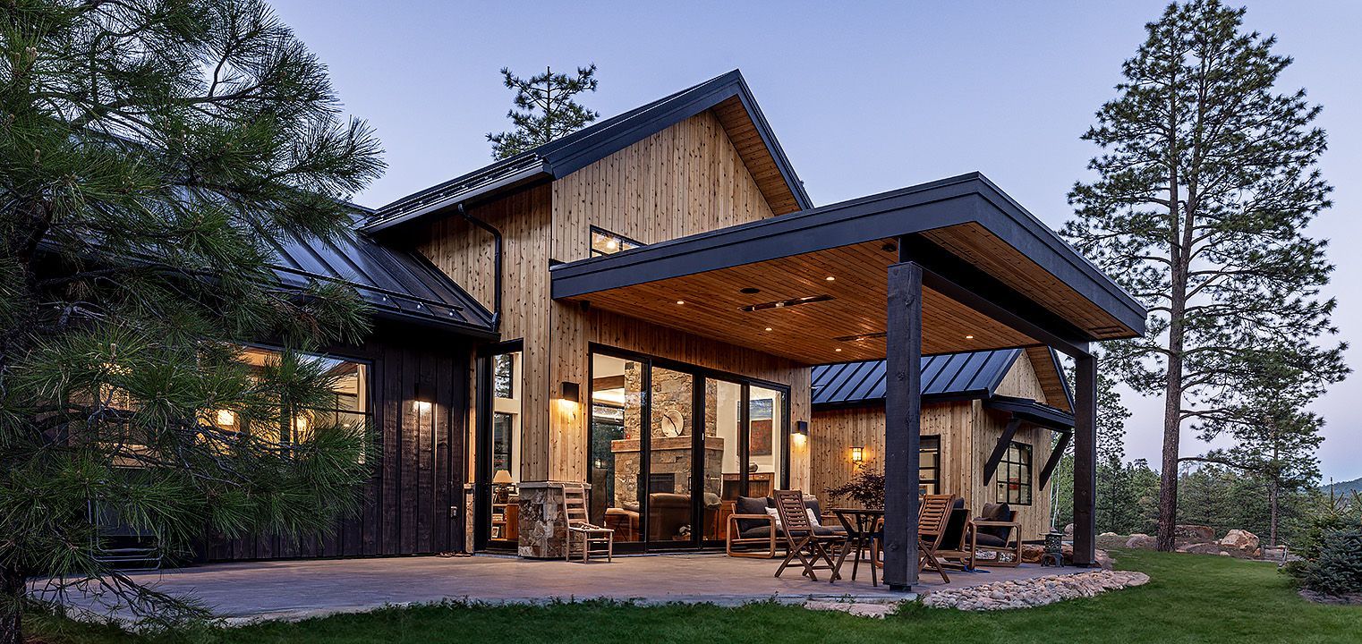 A large wooden house with a covered patio in front of it.