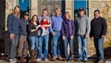 A group of people are posing for a picture in front of a building.