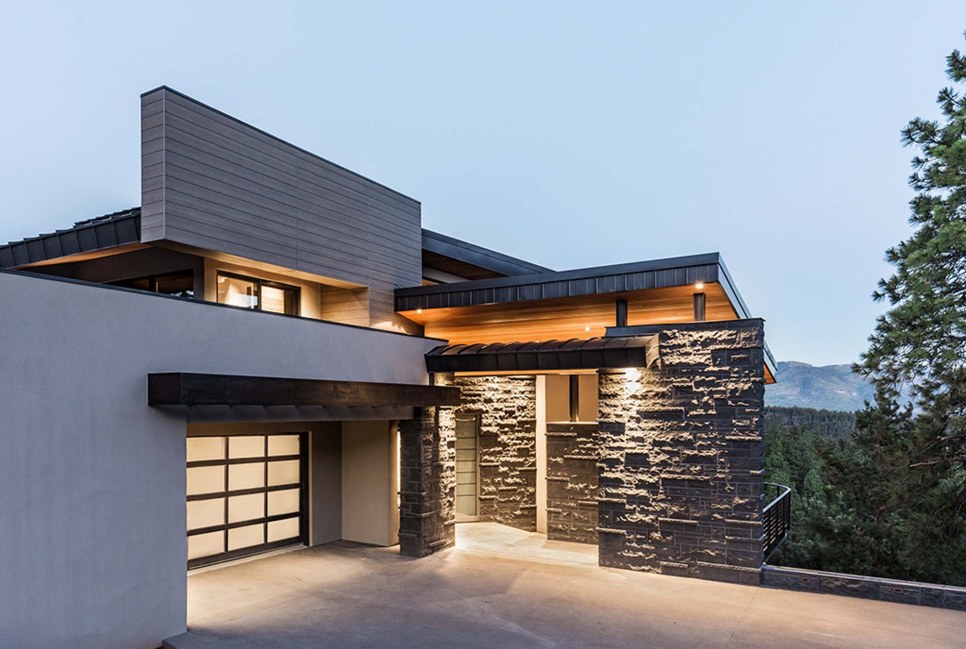 A modern house with a large garage and a driveway leading to it.