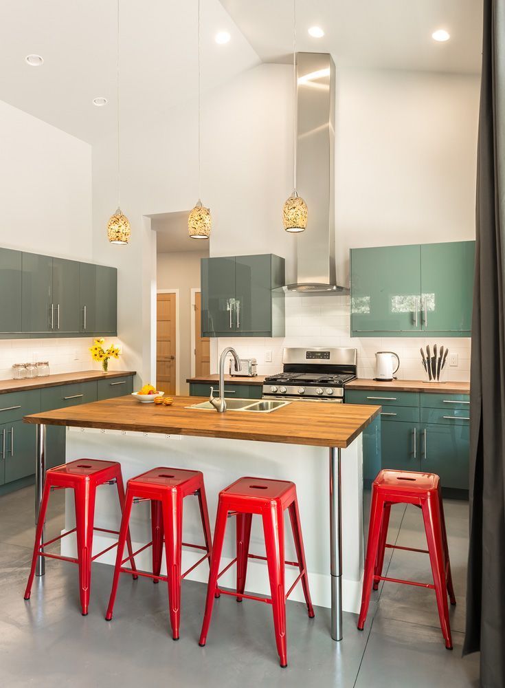 A kitchen with a large island and red stools