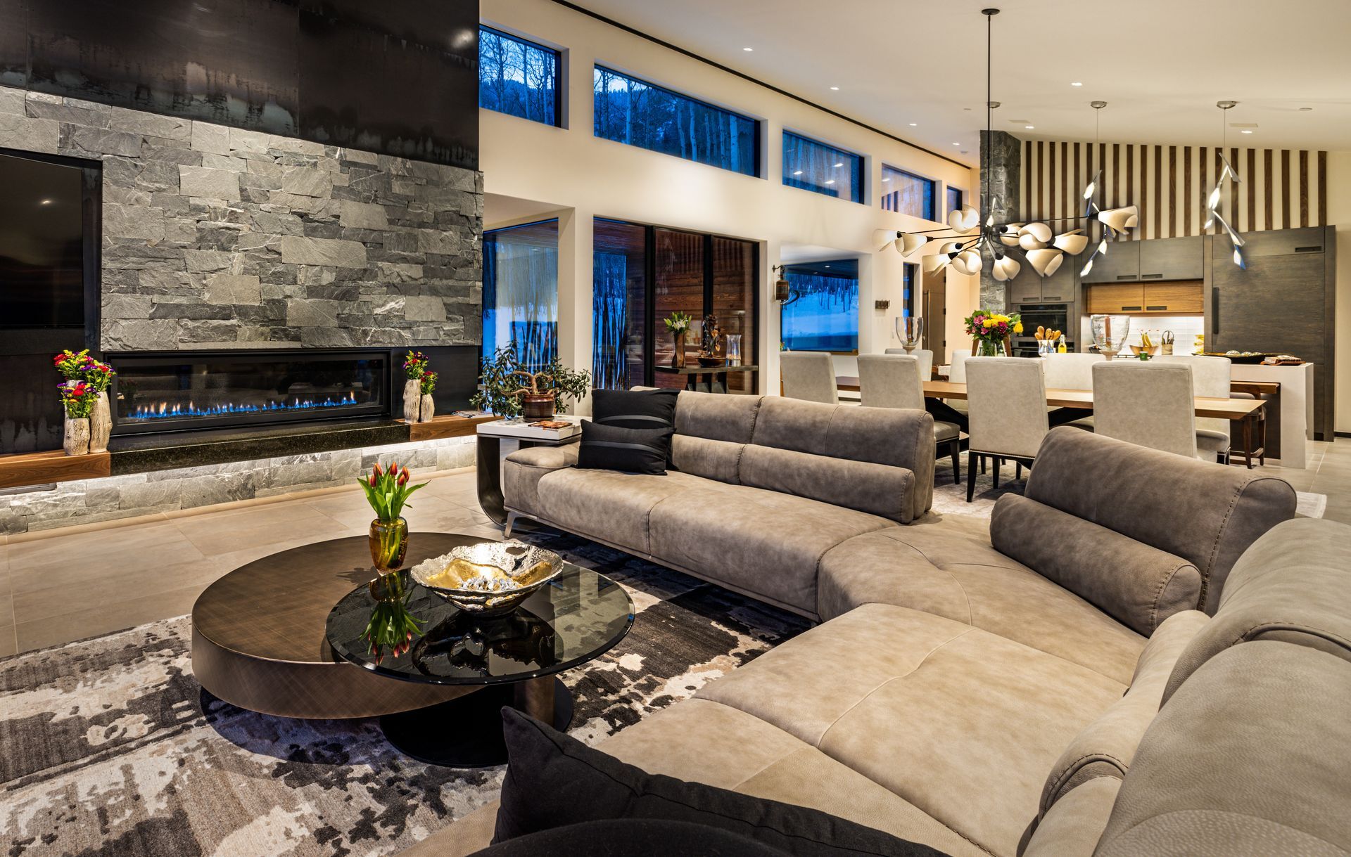 A living room with a couch , coffee table , fireplace and television.