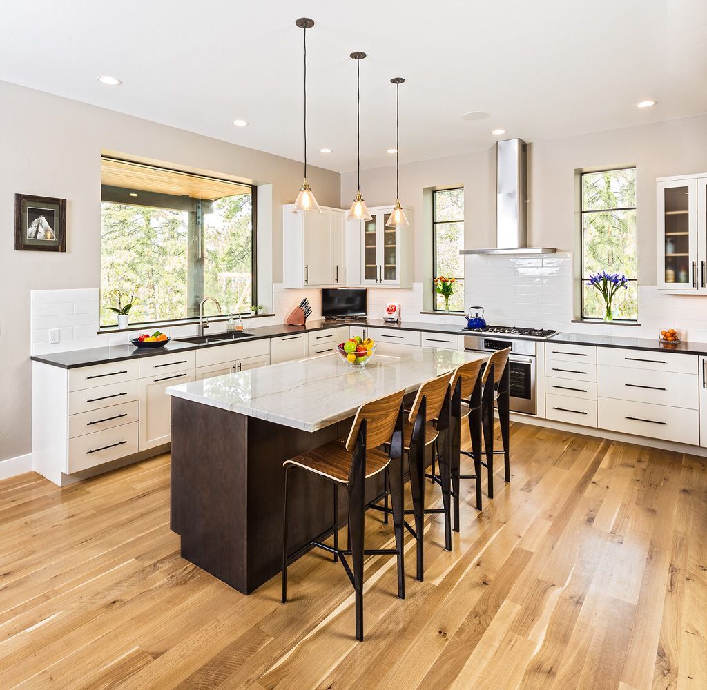 A kitchen with a large island and wooden floors
