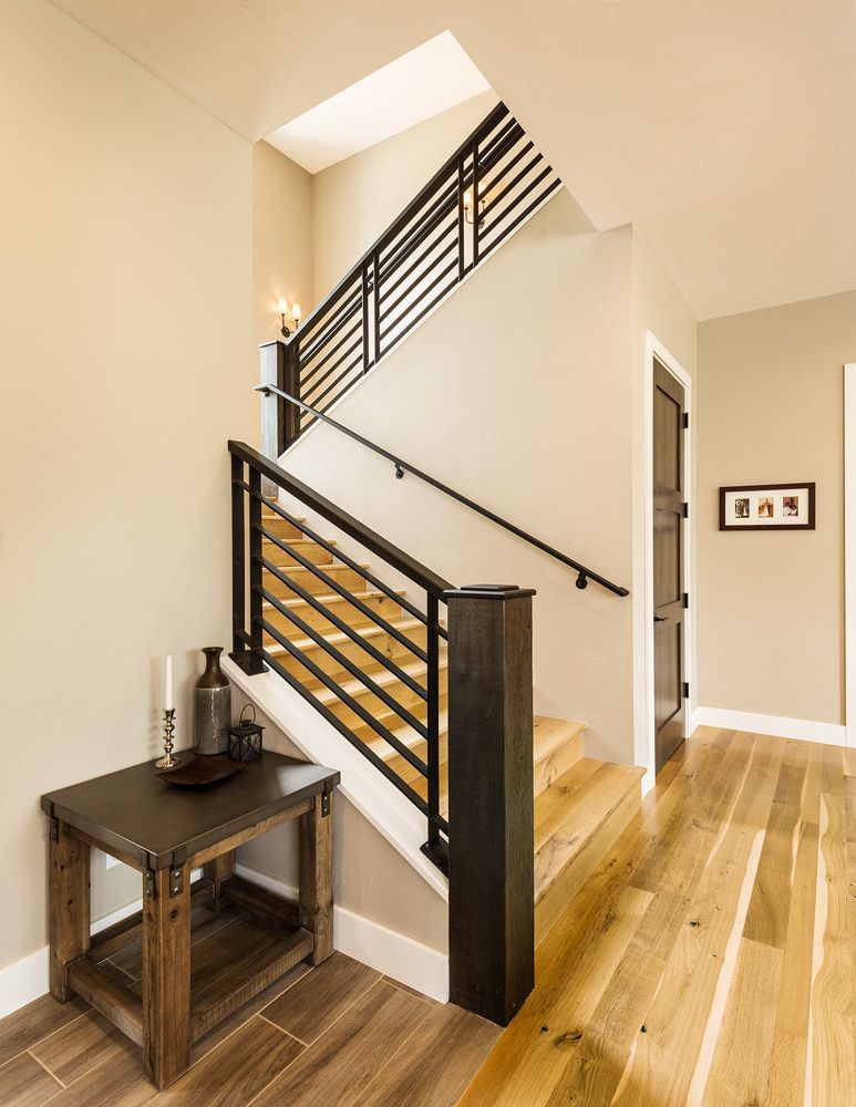 A staircase with a wooden railing and a wooden table underneath it