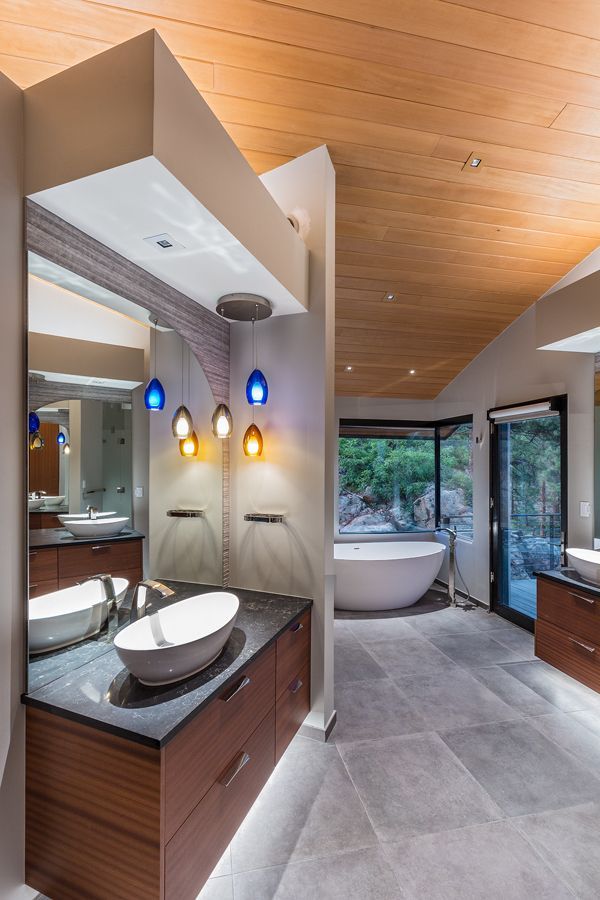 A bathroom with two sinks , a tub and a mirror