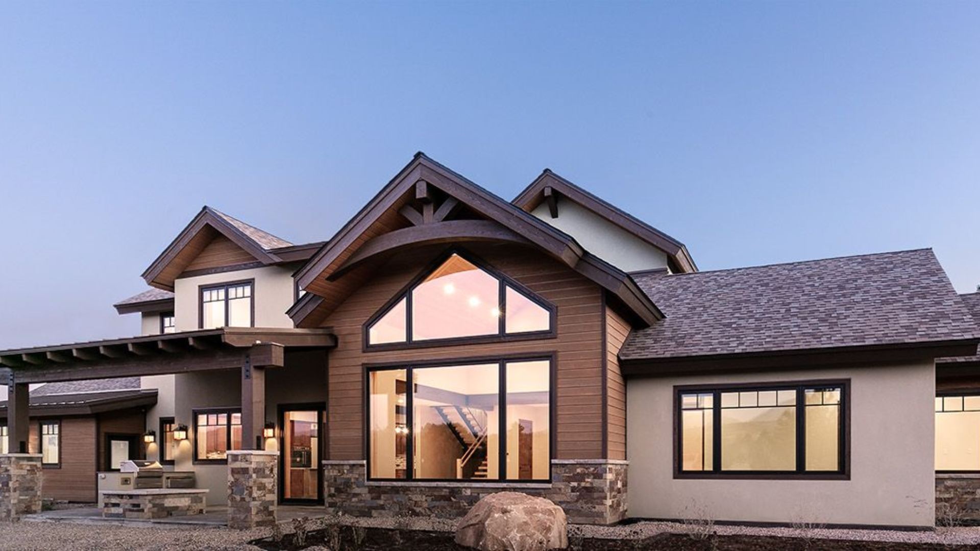 A large house with a lot of windows is sitting on top of a hill.