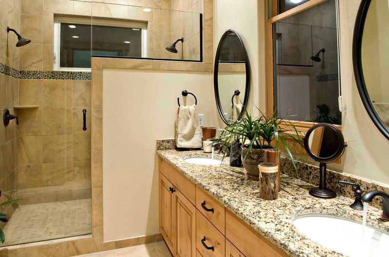 A bathroom with two sinks and a walk in shower