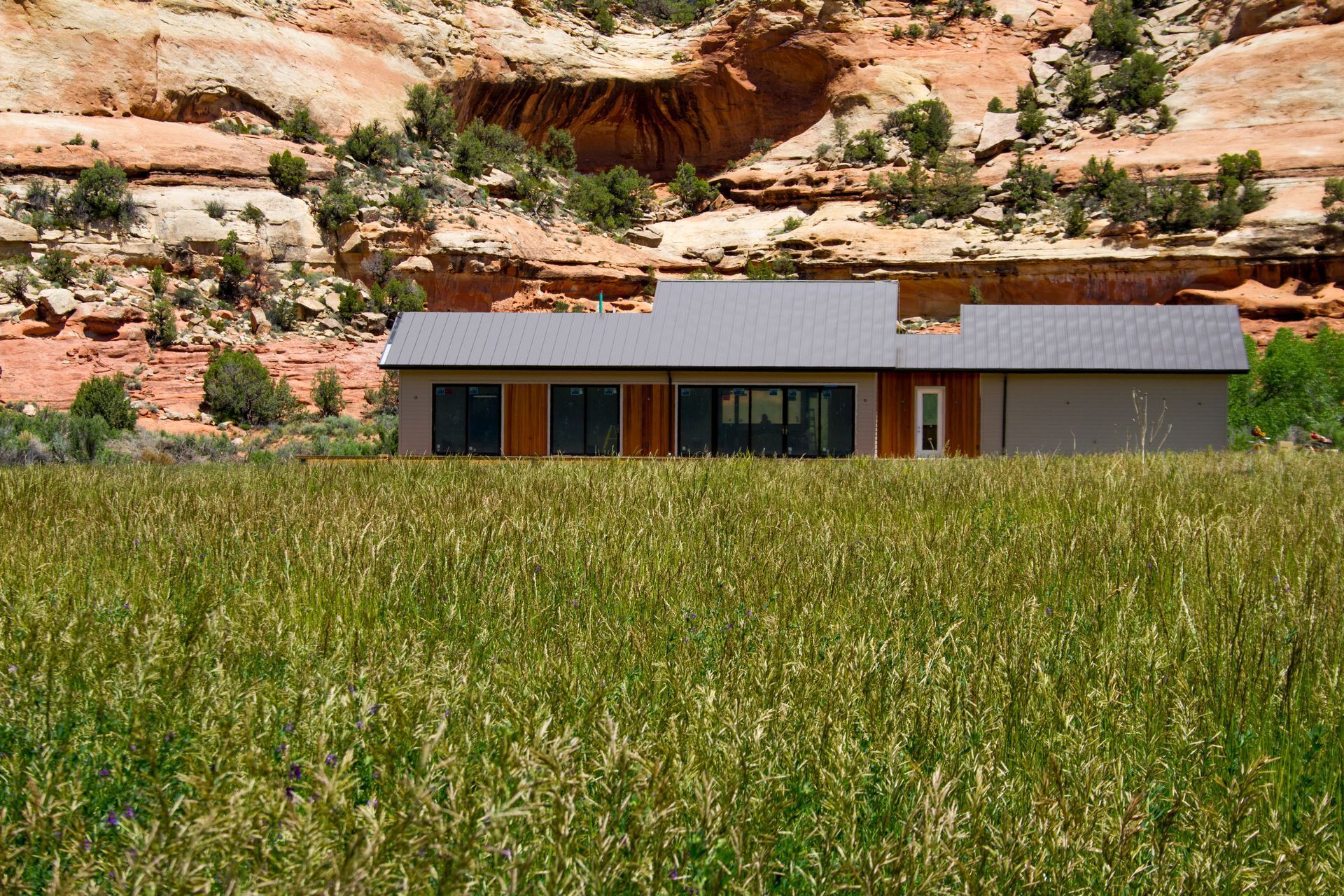 A house is sitting in the middle of a grassy field.