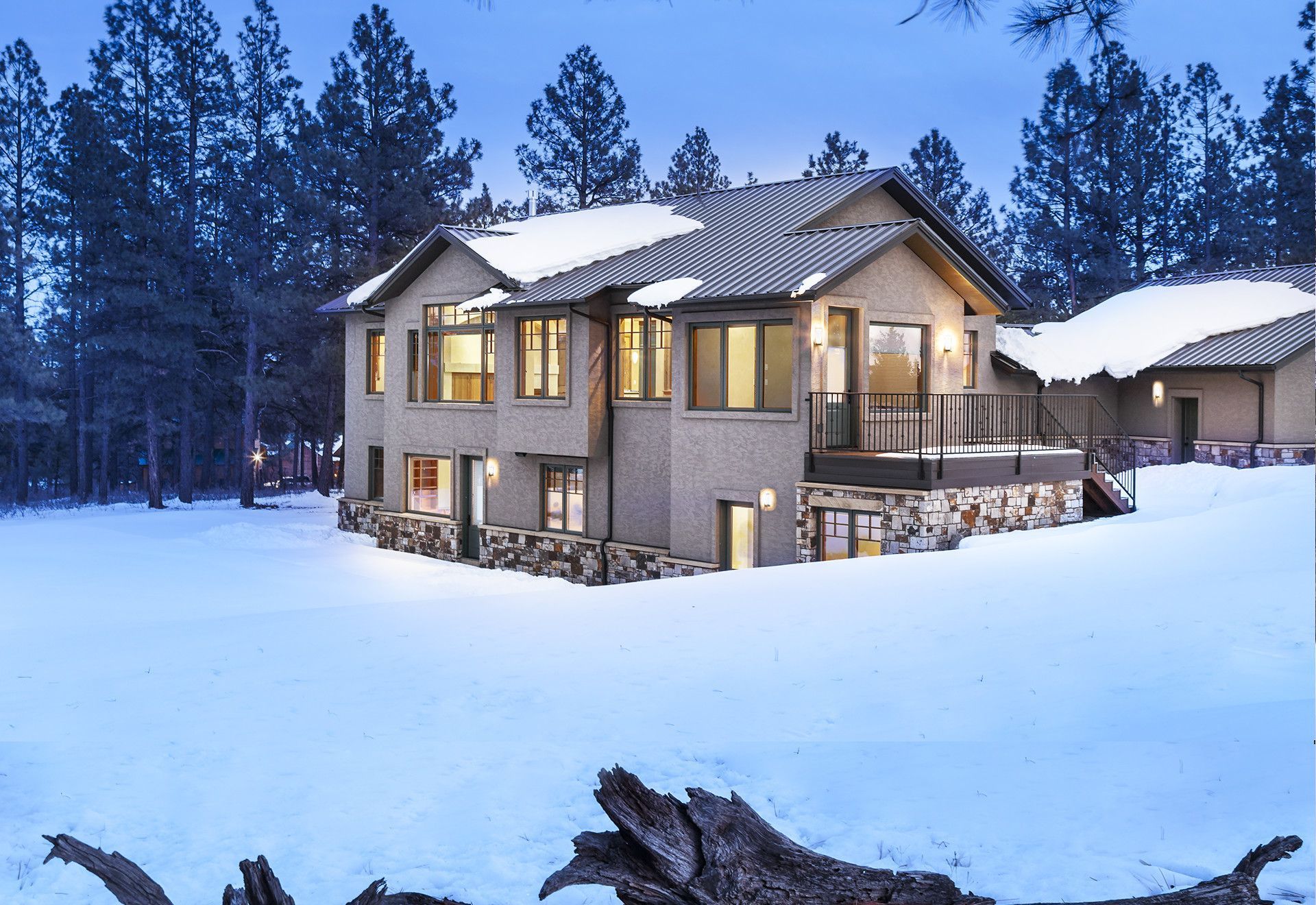 A house in the snow with trees in the background