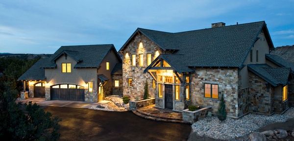 A large house with a lot of windows is lit up at night.